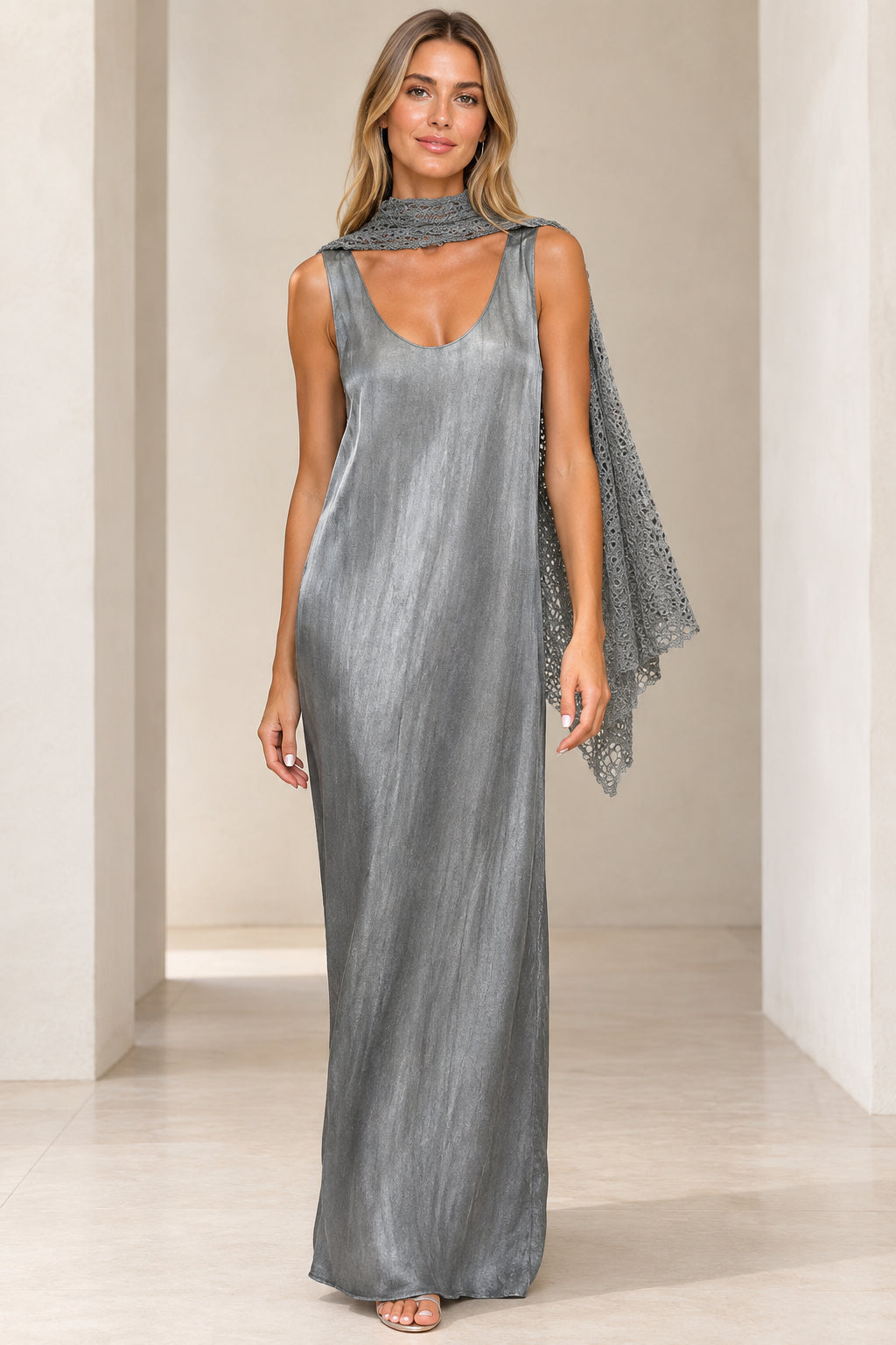 Front view of woman wearing silver shimmer sleeveless maxi dress with matching grey crochet scarf
