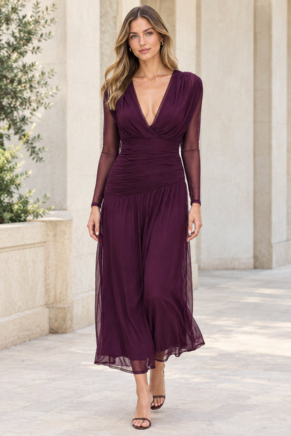 Front view of woman wearing plum deep V-neck ruched midi dress with sheer long sleeves