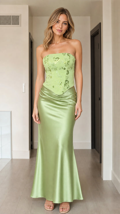 Front view of woman wearing strapless sage green sequin corset satin maxi dress