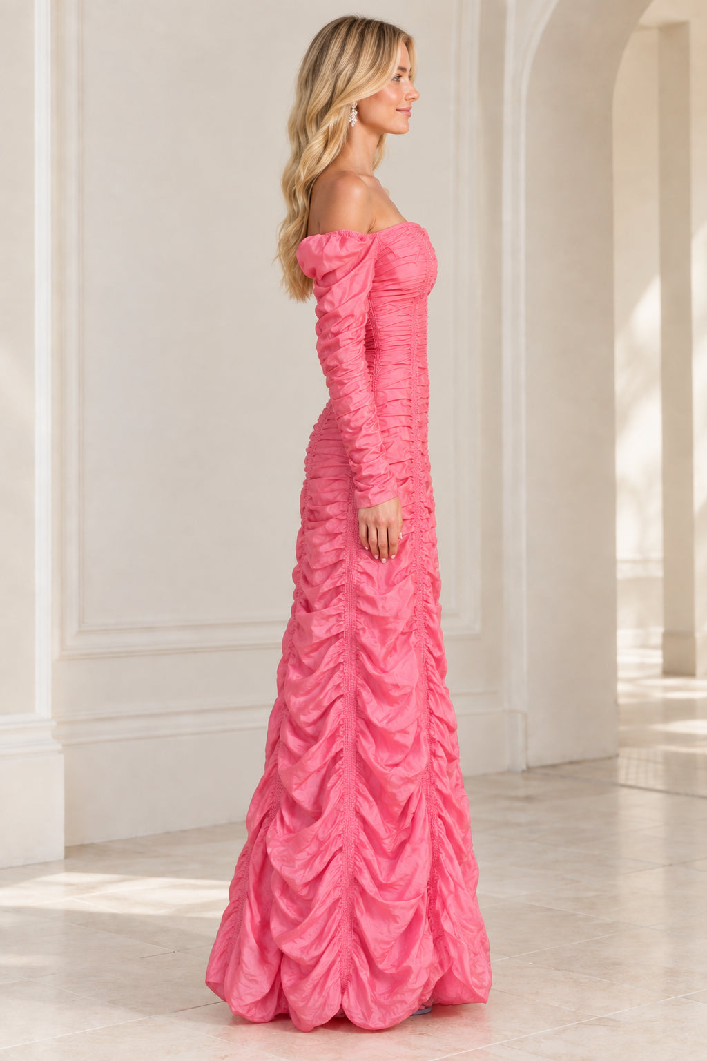 Side profile of woman in pink off-the-shoulder ruched formal gown