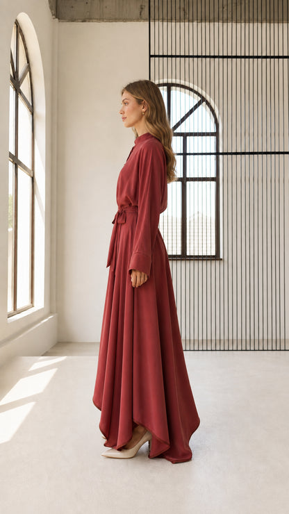 Side profile view of rust red belted maxi dress showing flowing draped skirt silhouette