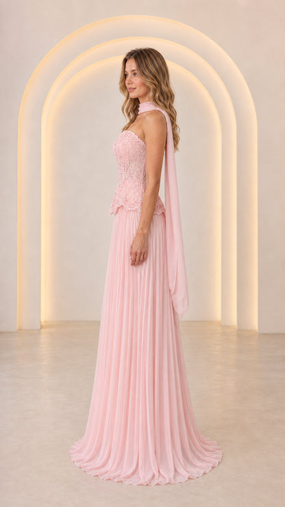 Side profile view of Blush Pink formal strapless gown with draped neck scarf and pleated maxi skirt