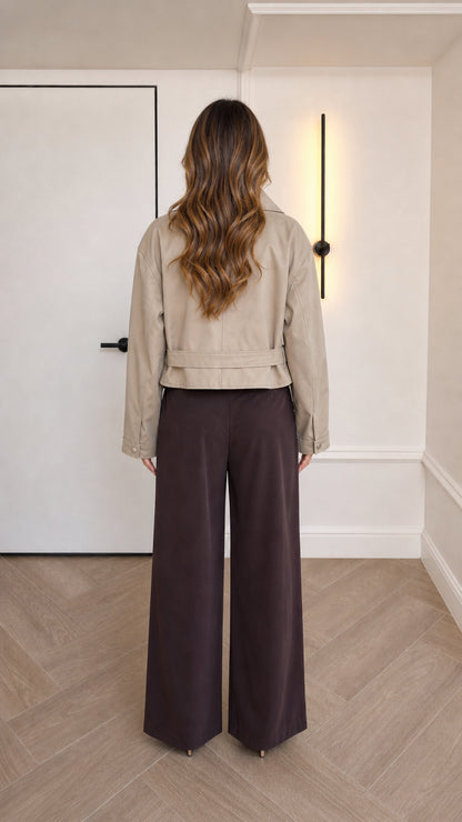 Back view of beige cropped faux leather jacket highlighting waist-length hemline