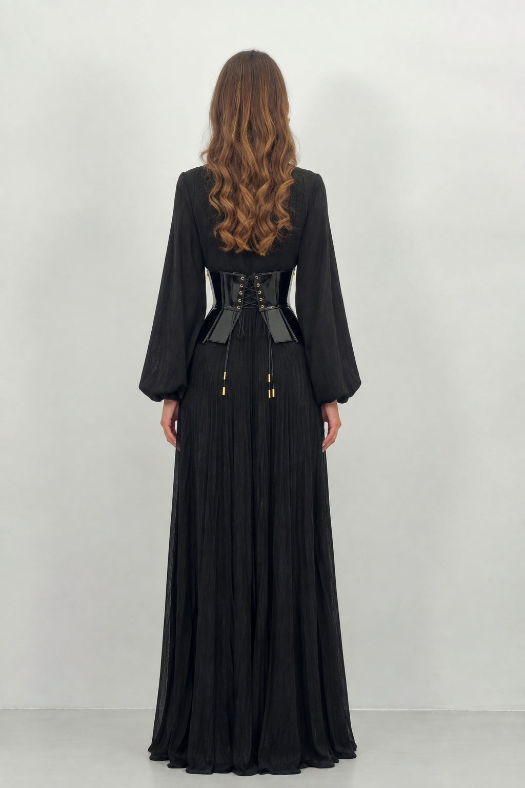 Back view of black pleated maxi dress with corset cincher
