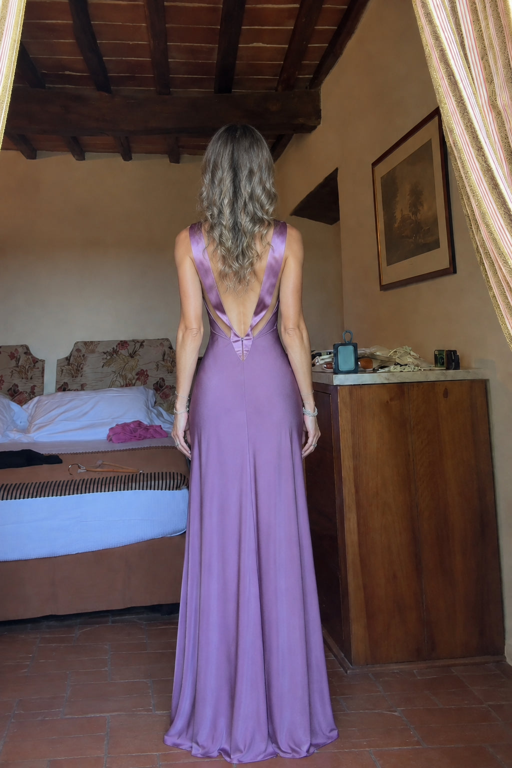 Back view of model showing open back and bow tie on mauve maxi dress