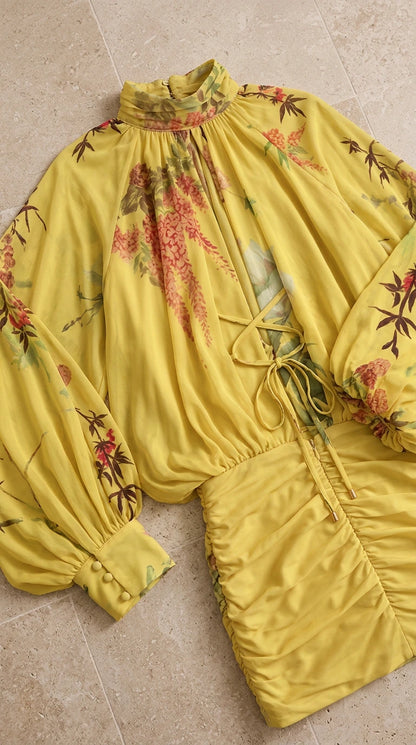 Flat lay close-up detail of yellow floral mini dress highlighting high collar and cuffs