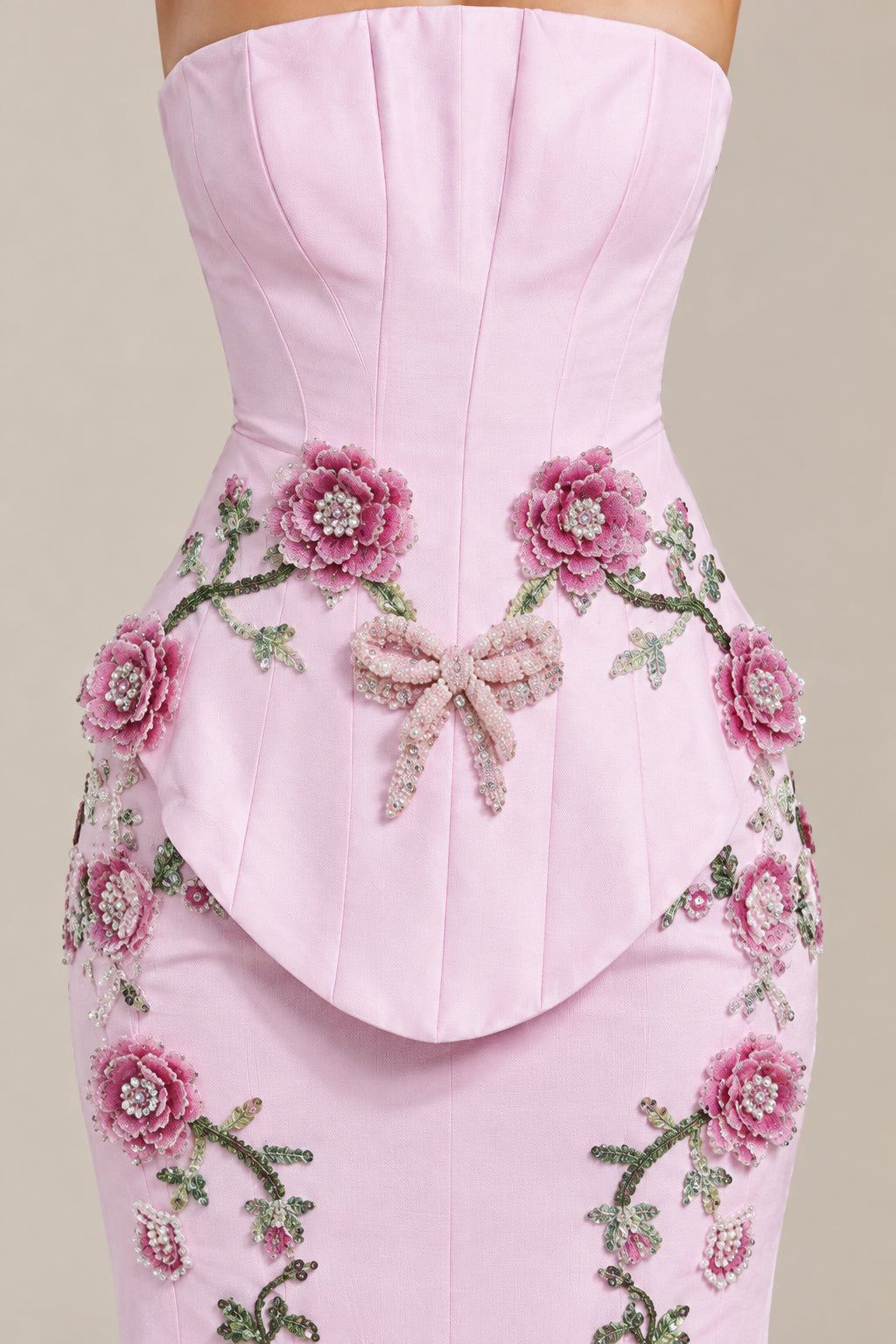 Close-up detail of Light Pink bodice, waist drape, 3D floral appliqués, and bow accent