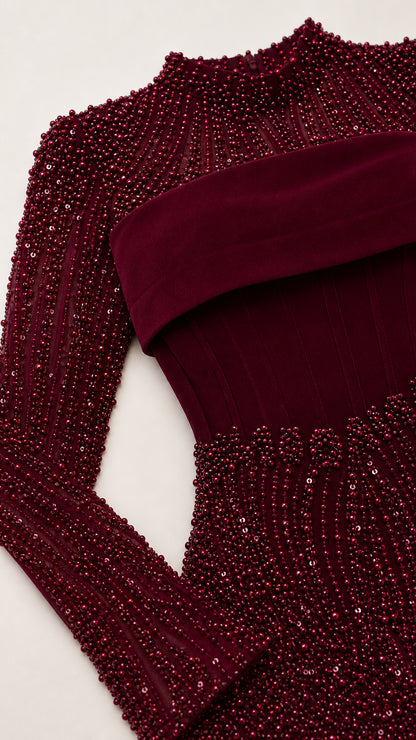 Close-up detail of burgundy beadwork and structured bodice overlay