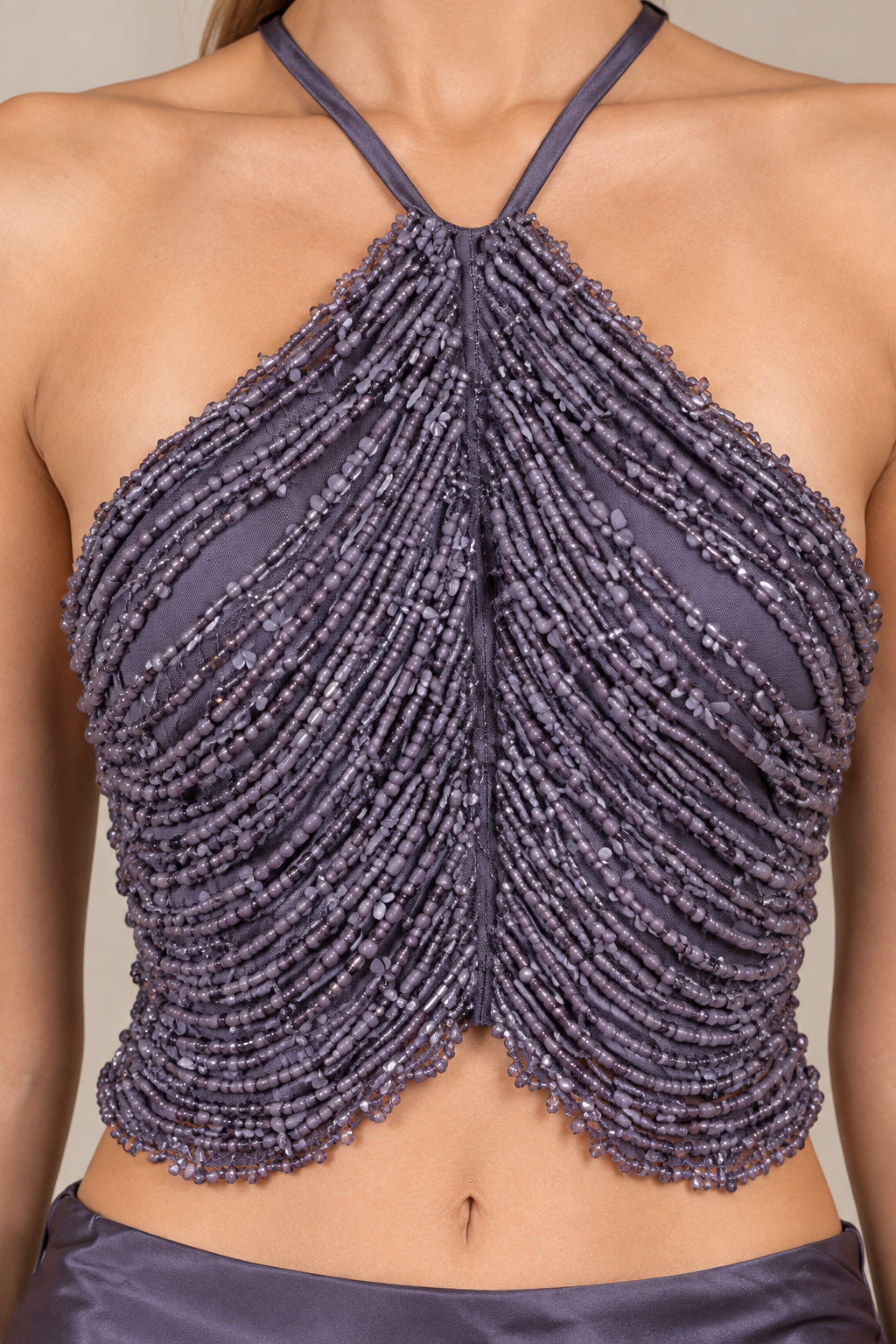 Close-up detail of dusty purple cascading beaded halter crop top bodice