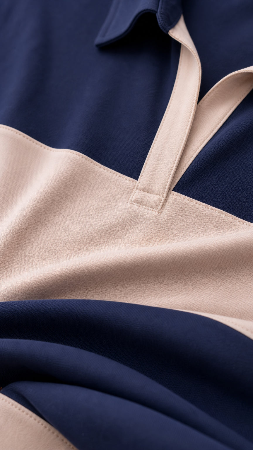Close-up detail of the spread polo collar and two-tone knit fabric