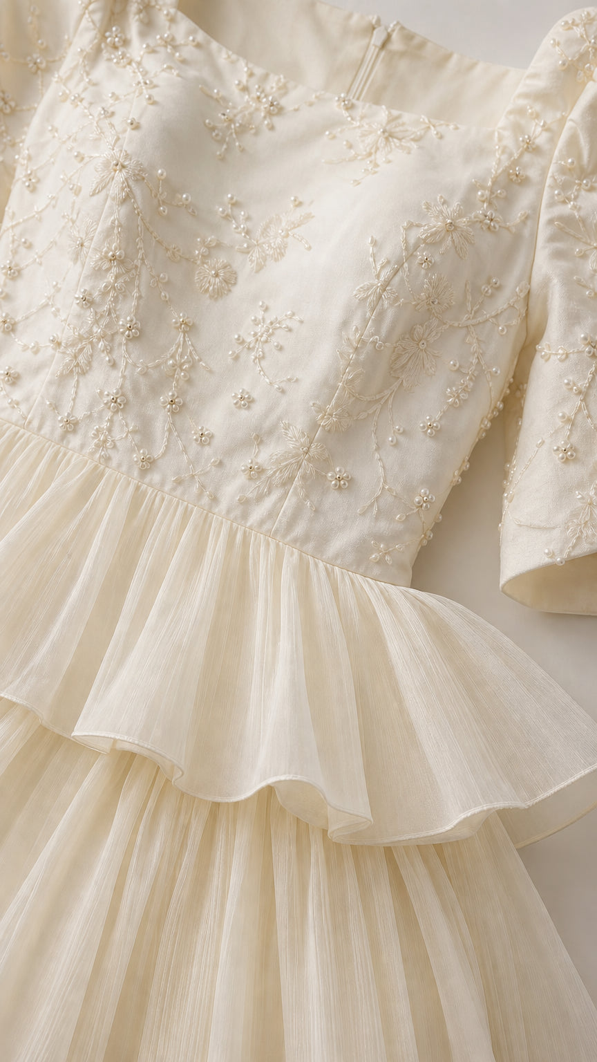 Close-up detail of delicate floral embroidery and tiered mesh tulle