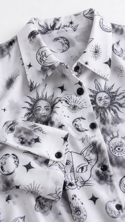 Close up detail of white fabric with celestial sun, moon, and cat graphic print and buttons