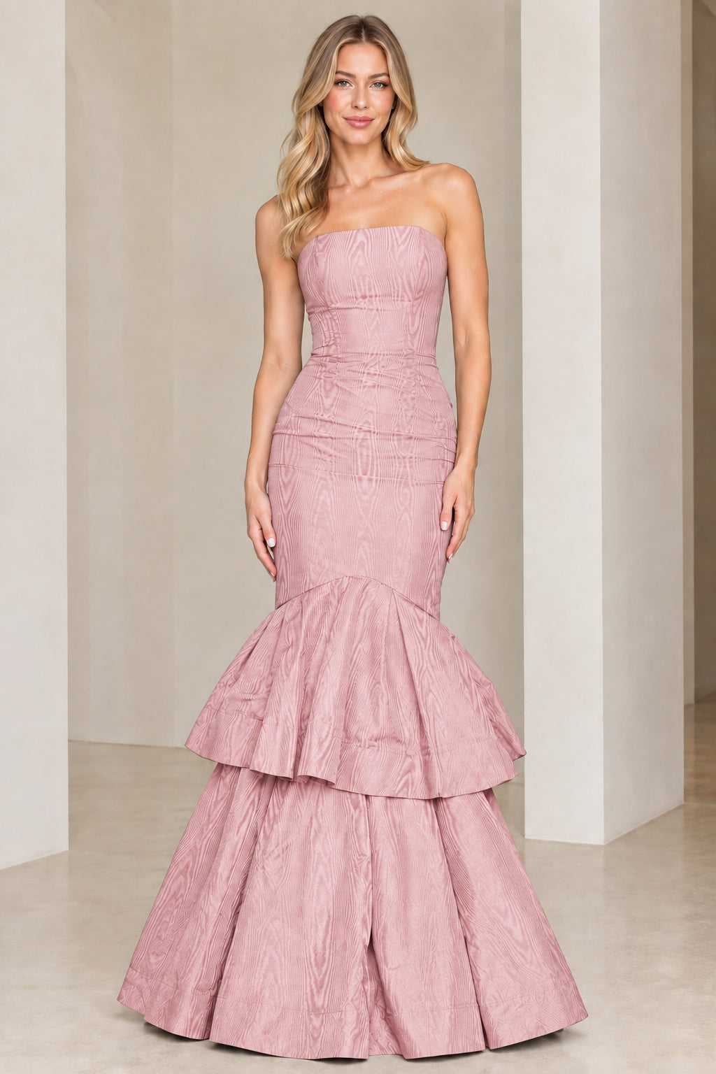 Model wearing dusty pink strapless tiered mermaid evening gown