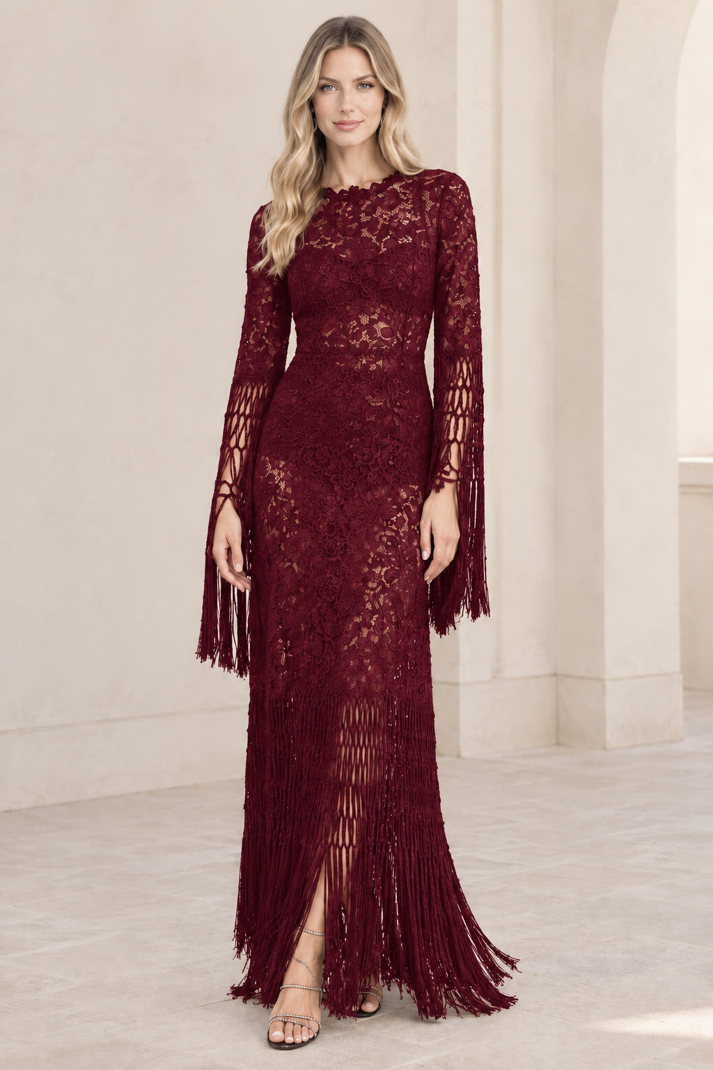 Model wearing burgundy red floral lace fringe maxi formal gown