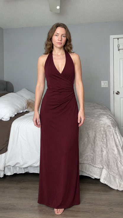 Front view of woman wearing burgundy wine red halter neck evening maxi dress