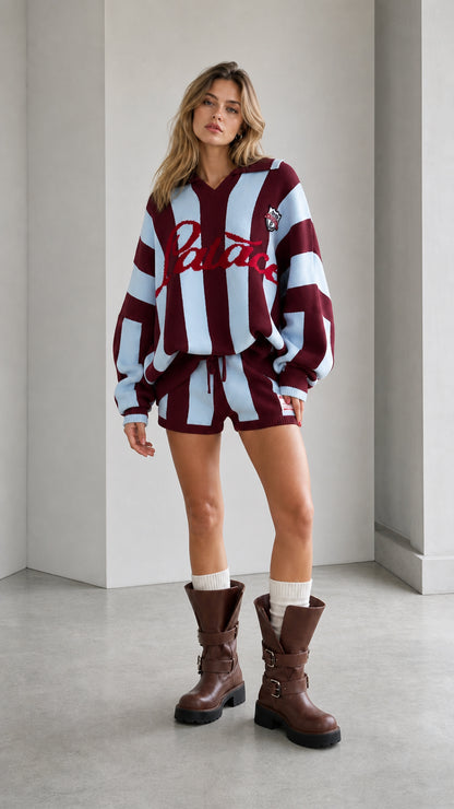 Model wearing burgundy and light blue striped knit polo and shorts set